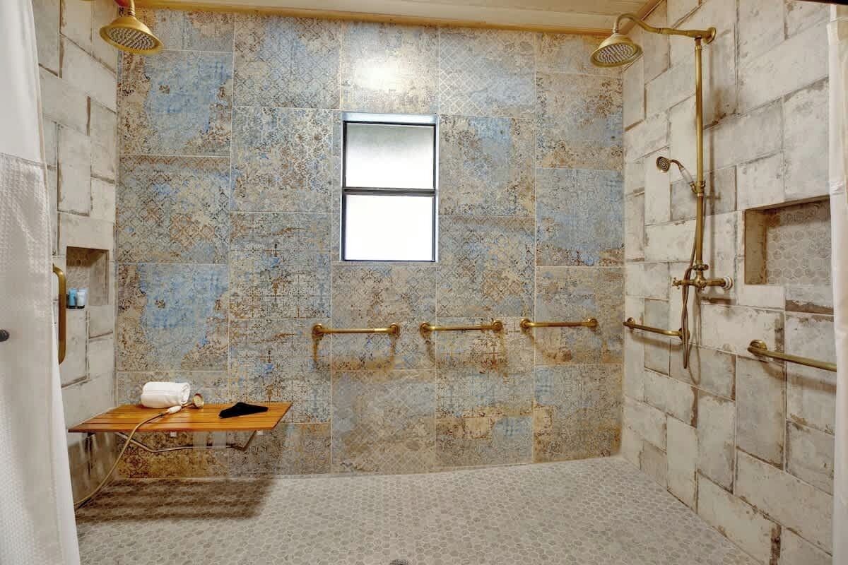 A bathroom with a shower, a window, and a towel rack.