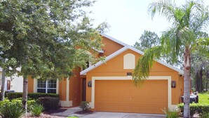 A single-story house with a garage, surrounded by a well-maintained lawn and various trees. - Private Pool Oasis! No Rear Neighbors! VALUE RATE! (Davenport)