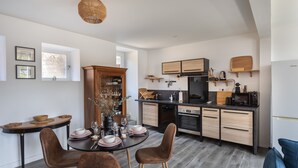 Une cuisine moderne avec un coin repas, comprenant une table ronde, des chaises et un meuble encastré.