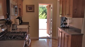 Uma cozinha com armários de madeira, fogão, torradeira e geladeira.