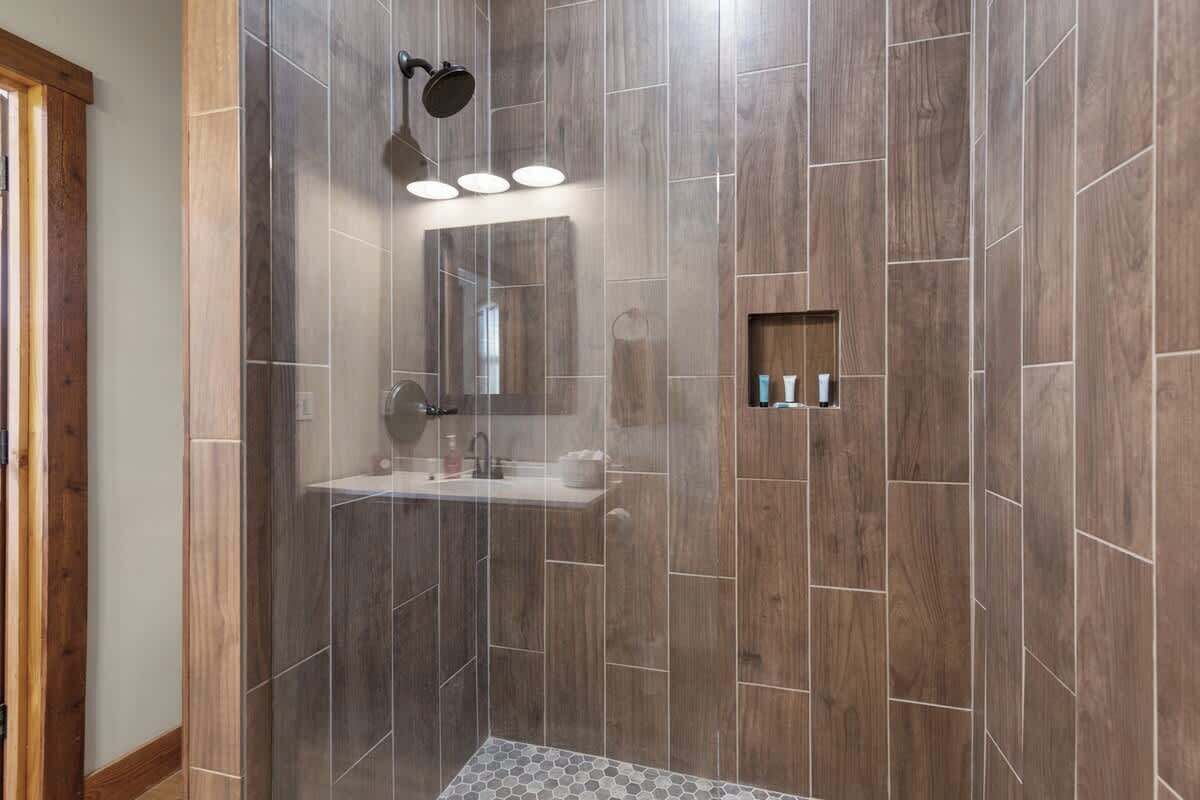 A modern bathroom with a shower, a sink, and a mirror.
