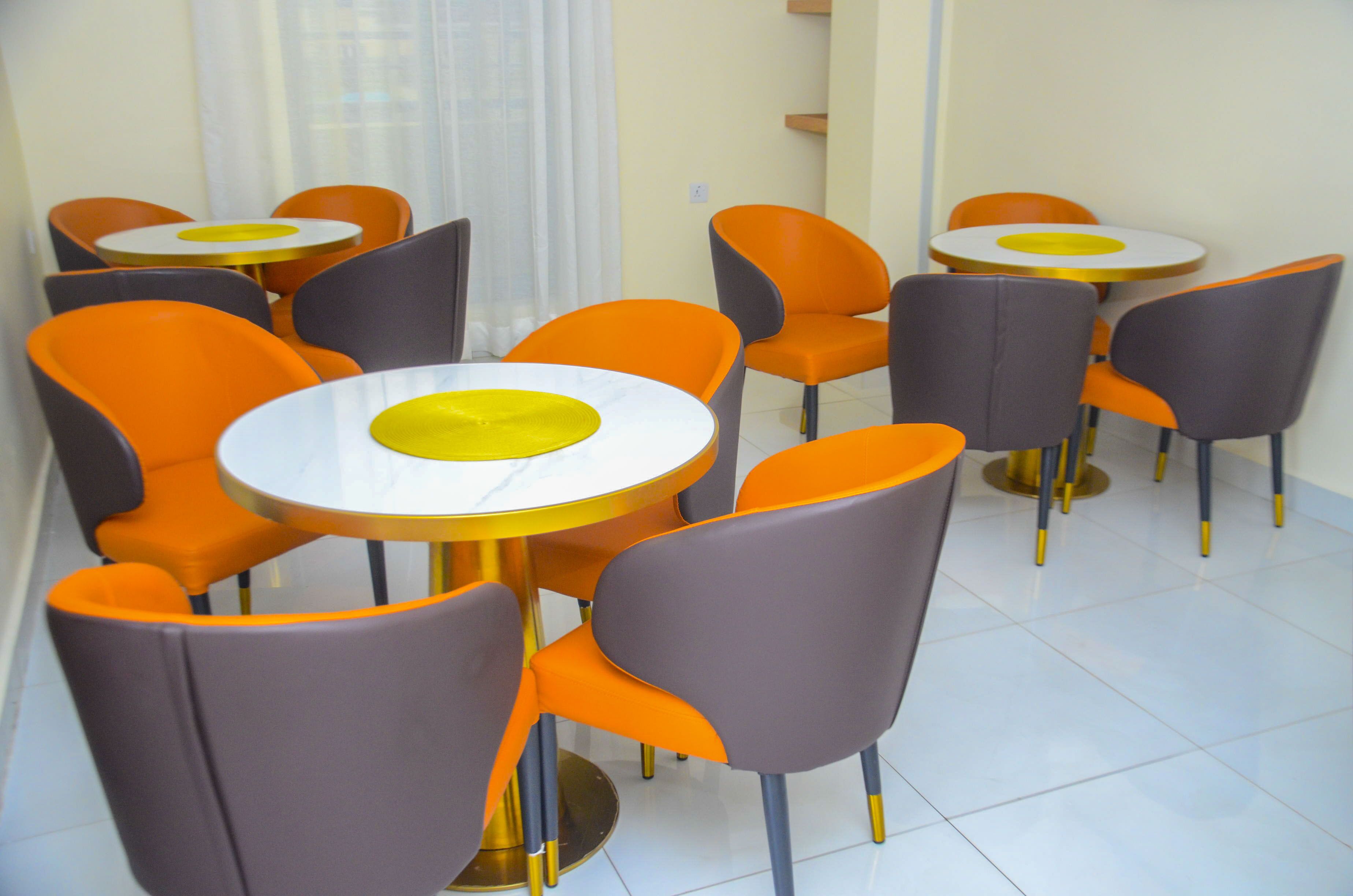 A dining area with round tables and chairs, featuring a yellow center on the tables.