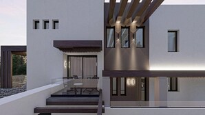 Ein modernes, mehrgeschossiges Haus mit Treppe, Sitzgelegenheit im Freien und einer überdachten Terrasse.