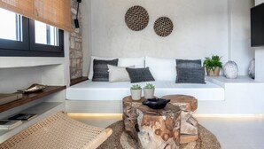 Ein modernes Wohnzimmer mit einem weißen Sofa, einem runden Couchtisch und einer Wand mit Steinverkleidung.