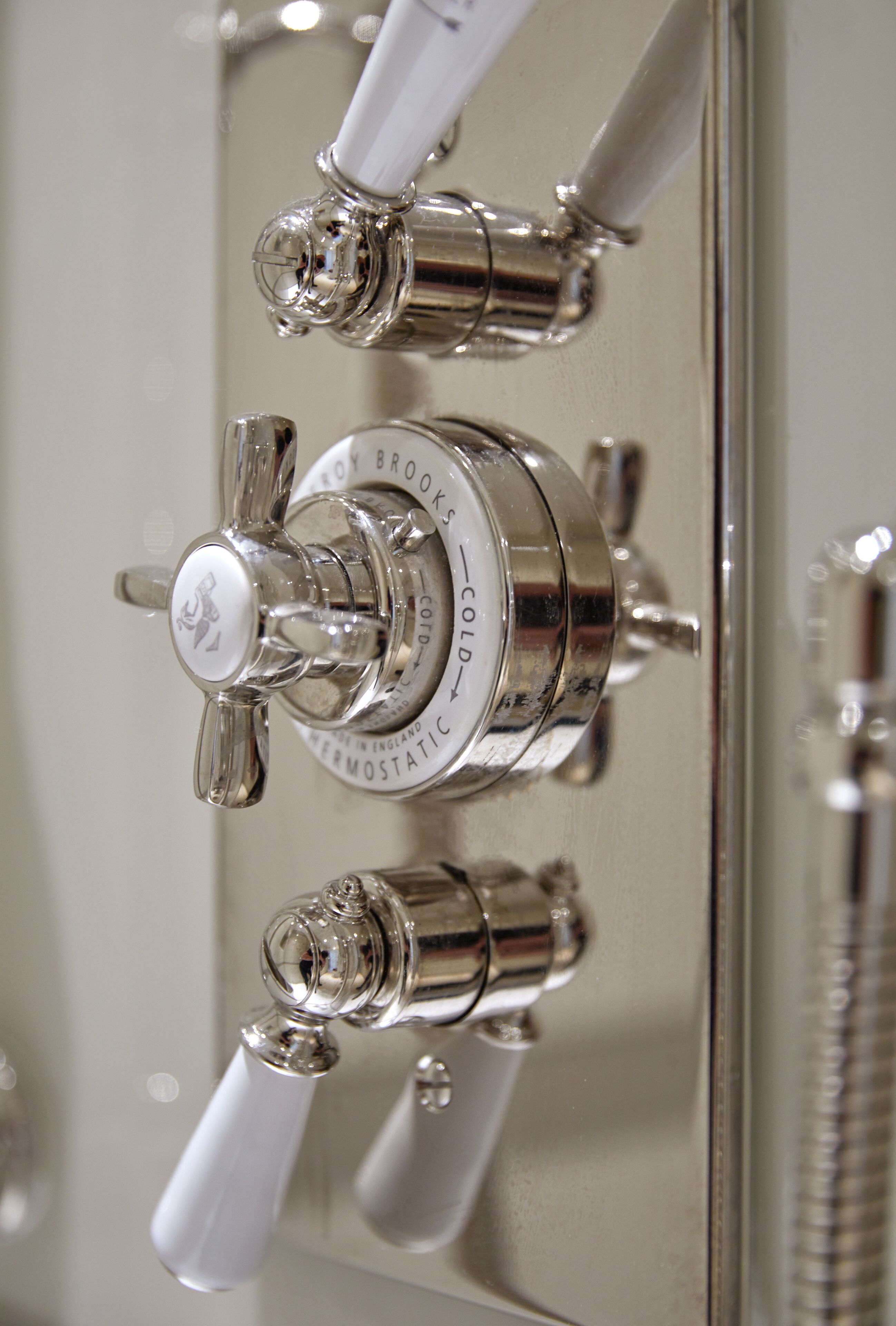 A bathroom with a chrome faucet and a mirror.