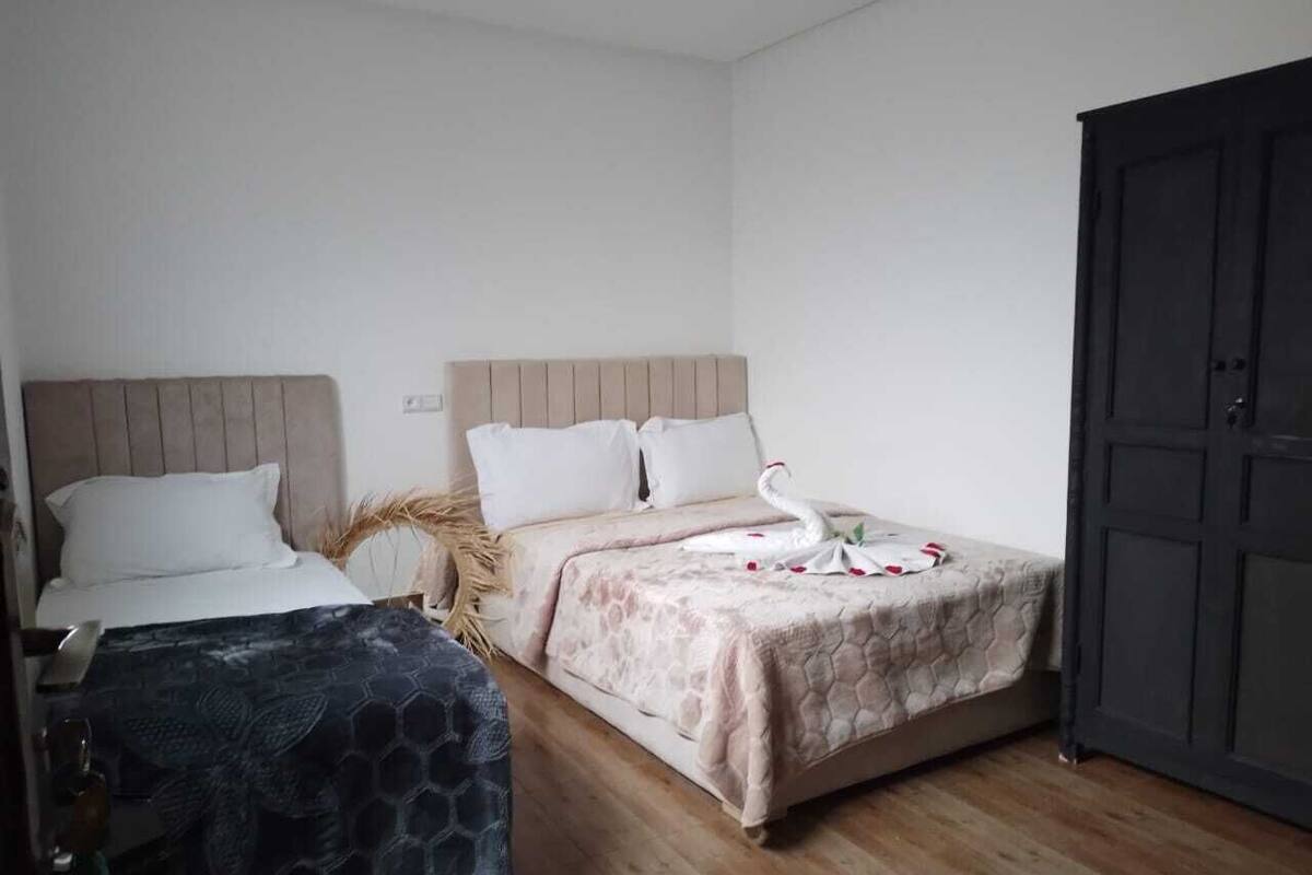 A bedroom with two beds, a wardrobe, and a wooden floor.