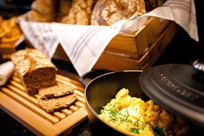 Enjoy a hearty breakfast with a selection of fresh bread and eggs.