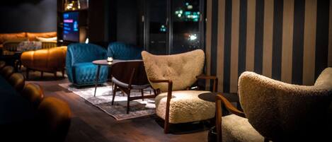 Un área de descanso moderna con sofás y sillones de cuero y una pequeña mesa.