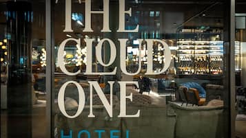 Un interior de hotel con un amplio ventanal que muestra el nombre "THE CLOUD ONE HOTEL".