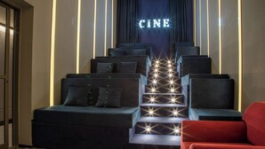 Un escalier sur le thème du cinéma, avec des sièges et un panneau néon indiquant le mot « CINE ».