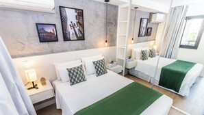Ein Hotelzimmer mit einem großen Bett, einem Nachttisch mit Lampe, einem Spiegel und gerahmten Bildern an der Wand.