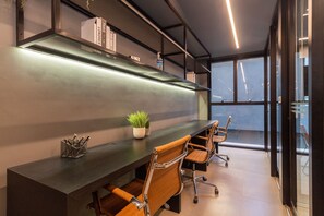 Conference room with a long table, leather chairs, and a geometric-patterned panel.