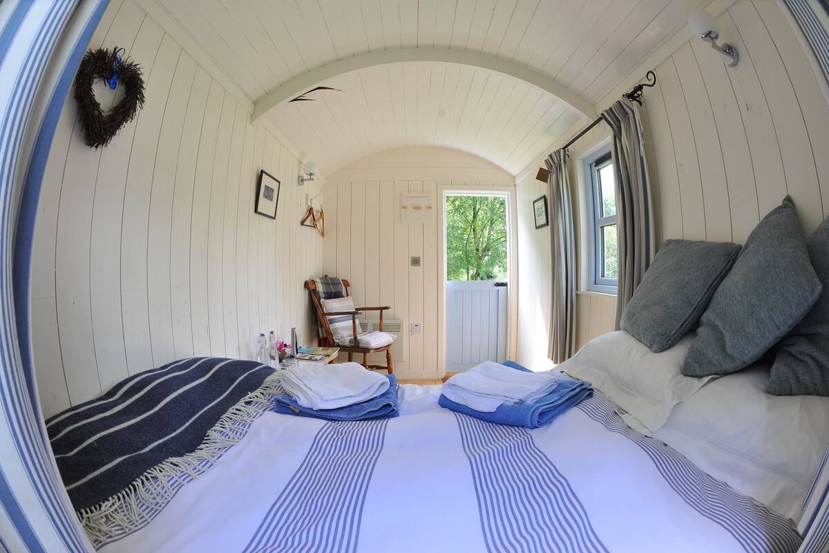 Une pièce confortable avec un lit, une chaise et une porte donnant sur l’extérieur.