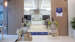 An office space with a reception area, wooden doors, and a '1st Birthday' sign.