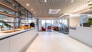 A modern office space with a reception area, seating, and a view of the cityscape.