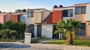A row of modern two-story houses with flat roofs, visible satellite dishes, and small front yards with palm trees. - Cuernavaca (Emiliano Zapata)