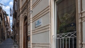 Eine enge Straße mit einem Gebäude, auf dem "MARINA DI ORTIGIA" steht.