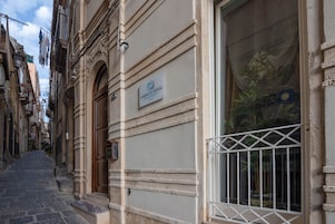 Una calle estrecha con un edificio que dice 'MARINA DI ORTIGIA'.