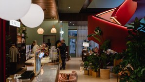 A modern hotel lobby with a bar area, seating, and potted plants. - Second Nature Belfast (Belfast)