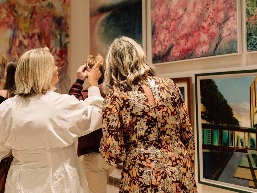 Un grupo de personas en una galería con grandes pinturas abstractas en las paredes.