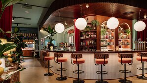 A bar area with a curved counter, multiple stools, and hanging spherical lights. - Second Nature Belfast (Belfast)