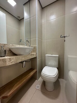 A modern bathroom with a white sink, faucet, and toilet. - Z Cotovia (São Paulo)