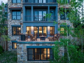 Un immeuble à plusieurs étages, doté d’une façade en pierre, de balcons et d’un intérieur bien éclairé.