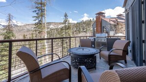 A balcony with wicker furniture, a round table, and a grill. - Cassidy Ridge D101 Condo (Mountain Village)