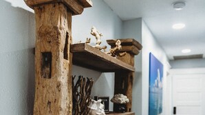 Ein rustikales Regal aus Holz mit verschiedenen dekorativen Gegenständen und einem gewebten Korb.