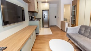 A modern kitchen with a built-in refrigerator, a wooden countertop, and a white dining table. - 360 For Consolação (São Paulo)