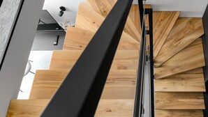 Una escalera moderna con escalones de madera y barandilla de metal.