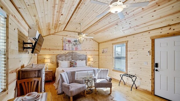 Ein gemütliches Blockhaus-Interieur mit Bett, Sitzecke und Esstisch.