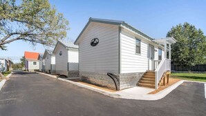 A row of mobile homes with a paved driveway and a wooden staircase leading to the front. - Gorgeous Cabin on Main-steps to Pacific War Museum (Fredericksburg)