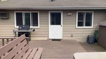Une maison avec une terrasse, une porte et une fenêtre.