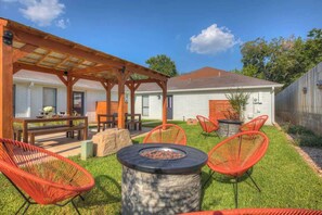 A backyard with a wooden pergola, a fire pit, and outdoor seating. - Wanderlust #1 Hot Tub Shared Outdoor Space (Fredericksburg)