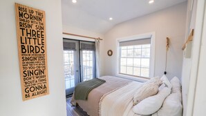 Ein Schlafzimmer mit Bett, Fenster und einer Wand mit einem Poster.