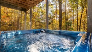 A hot tub in a forested area with a wooden roof. - Rockin R Lodge (Sevierville)