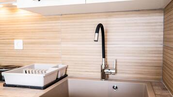 A modern kitchen with a built-in sink, a black faucet, and a white countertop.