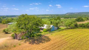 A rural landscape with a barn, trees, and open fields. - Historic Log Cabin Retreat Near Town on 5 Acres! (Fredericksburg)