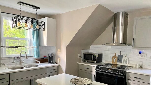 Una cocina moderna con una isla central, electrodomésticos de acero inoxidable y un ventanal con vistas.