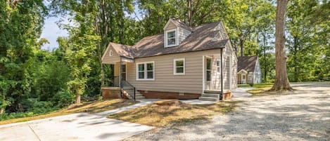 A single-story house with a front porch, a driveway, and a well-maintained lawn.