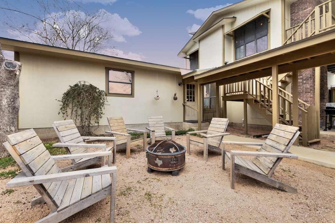 Un espace extérieur aménagé avec des chaises Adirondack et un foyer.
