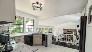 Een ruime keuken met een groot kookeiland, inbouwapparatuur en uitzicht op de omgeving.