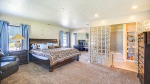 A bedroom with a large bed, a nightstand, a chair, a dresser, and a walk-in closet with shelves. - Centrally Located Hampton Home: 6 Mi to Downtown! (Hampton)