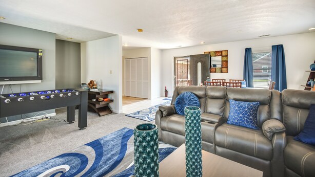 A living room with a foosball table, a leather sofa, and two decorative vases. - Centrally Located Hampton Home: 6 Mi to Downtown! (Hampton)