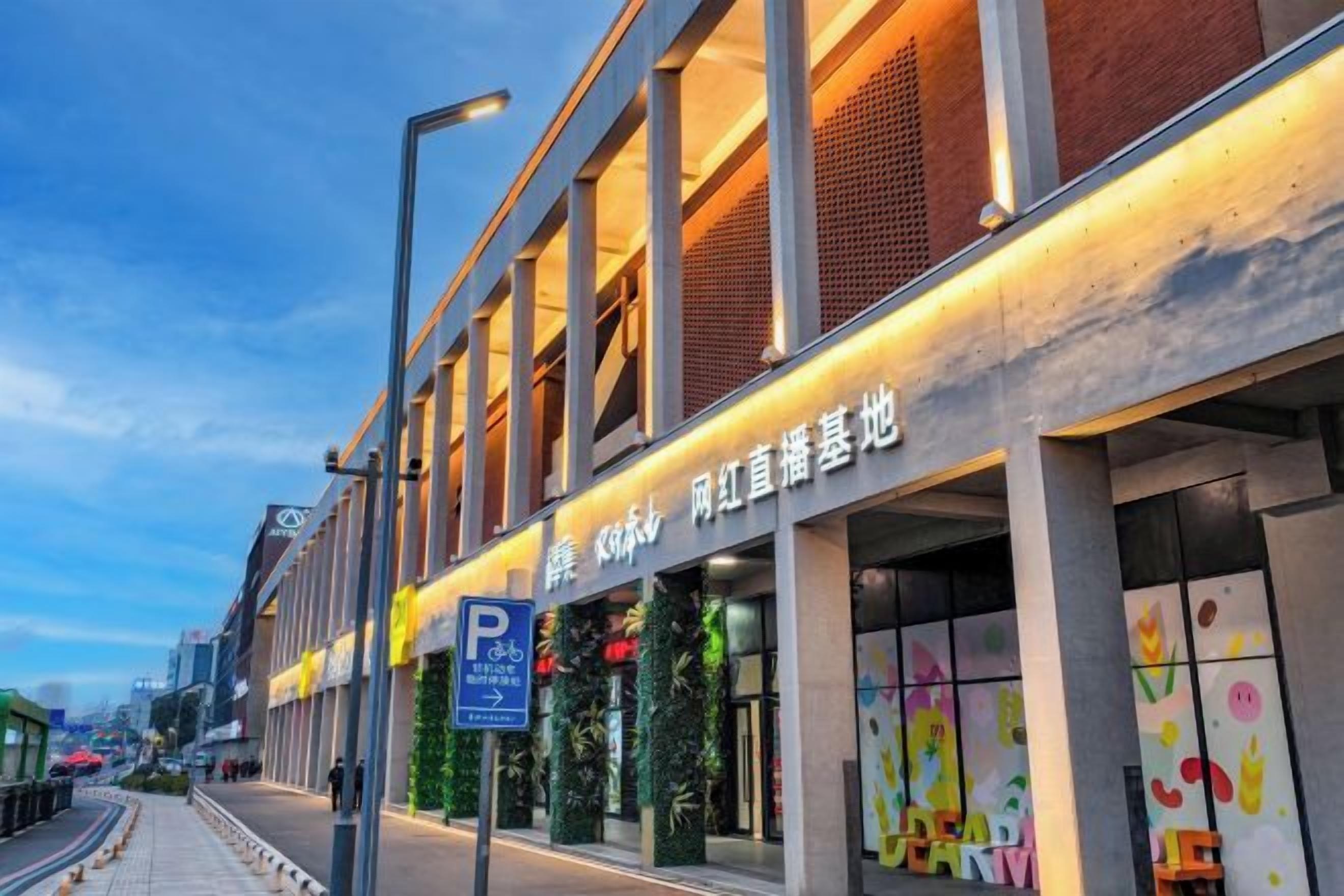 A building with a storefront featuring a sign with Chinese characters, a parking sign, and a pedestrian walkway.