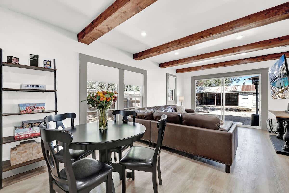 Una sala de estar moderna con una mesa de comedor, sillas, un sofá y una estantería.