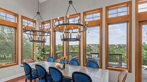 Ein Essbereich mit einem großen Tisch, blauen Stühlen und einer Chandelier.