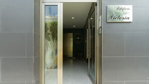 Een modern gebouw met een glazen deur, een bord waarop 