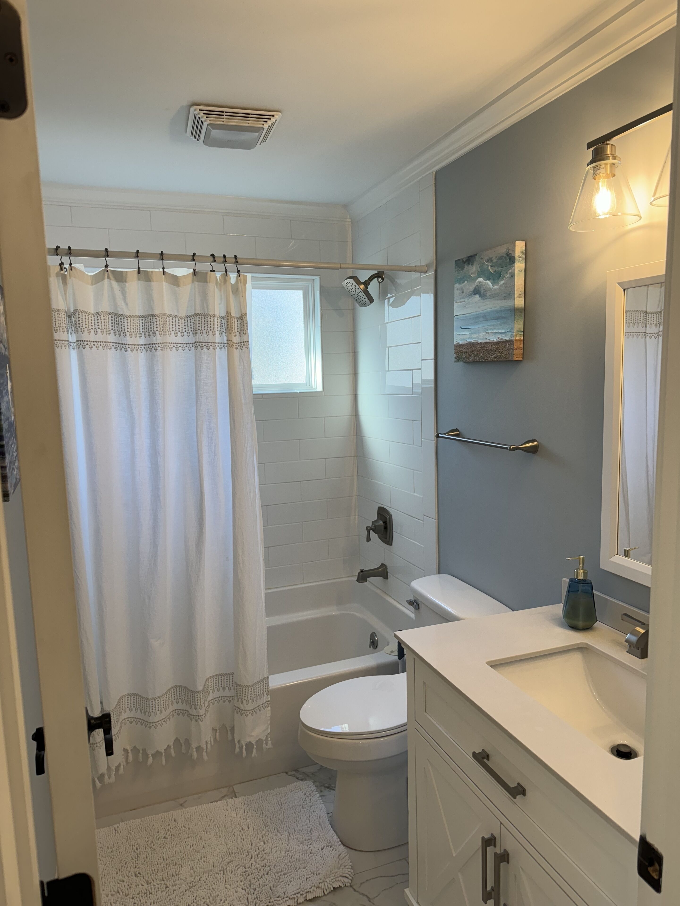 A bathroom with a bathtub, toilet, and sink.